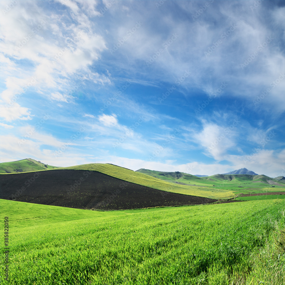 Hills Grass Land Below White Clouds And Blue Sky Of Sicily Countryside