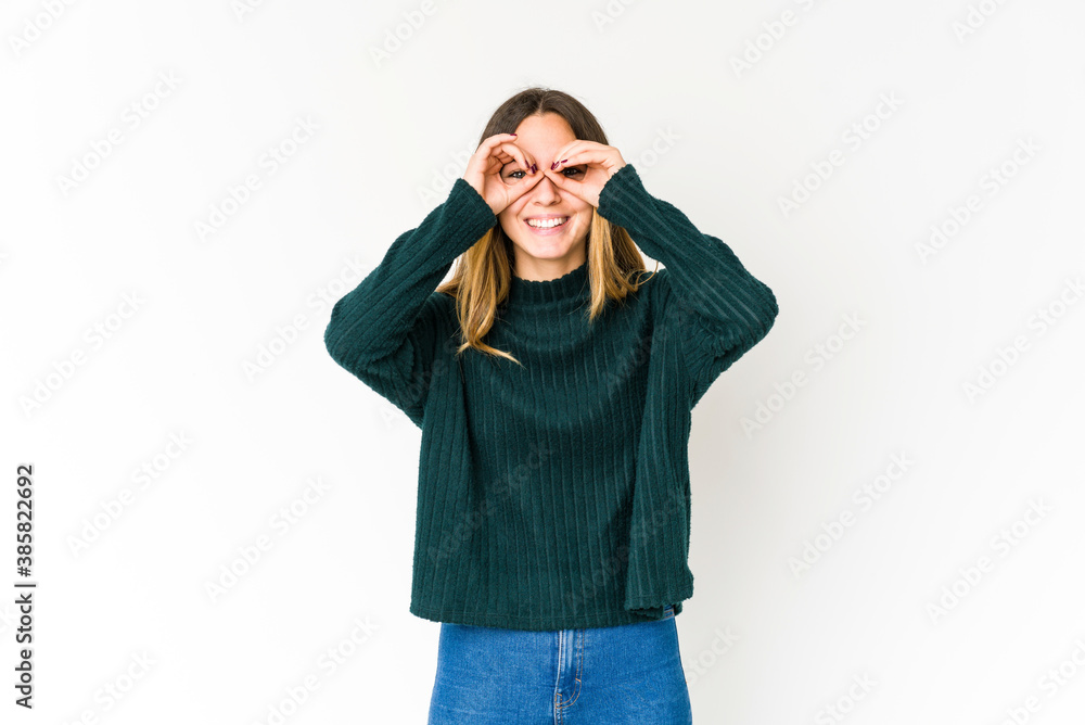 Young caucasian woman isolated on white background showing okay sign over eyes Young caucasian woman isolated on white background showing okay sign over eyes