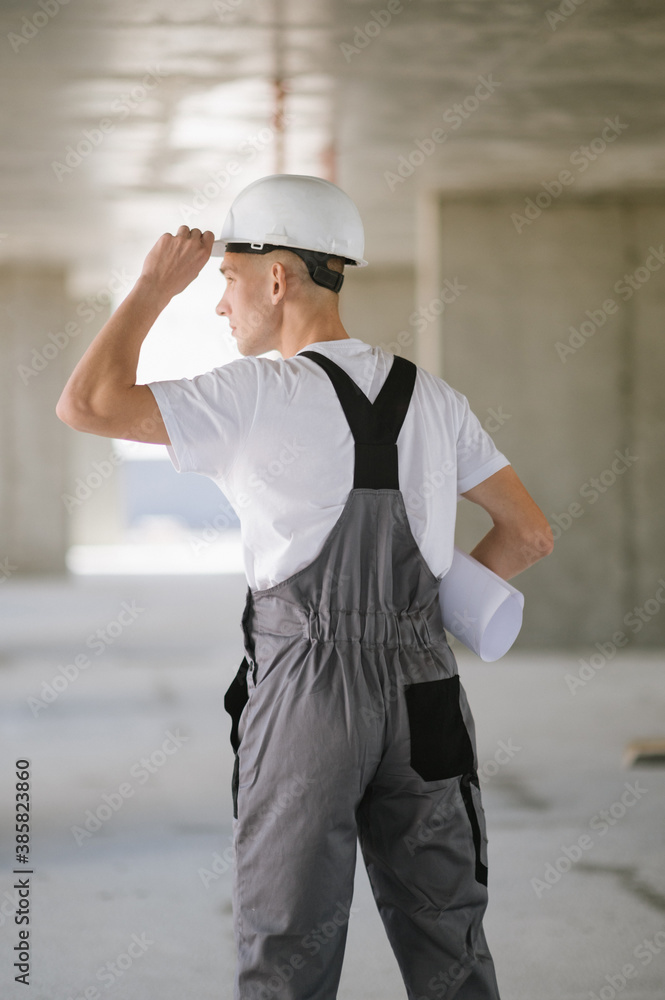A construction worker with blueprint.Young worker at construction site with blueprint A construction worker with blueprint.Young worker at construction site with blueprint