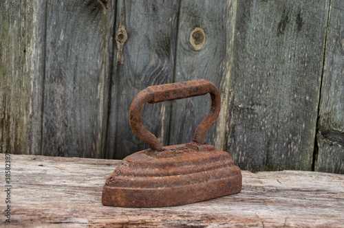 Antique iron on a natural wooden background