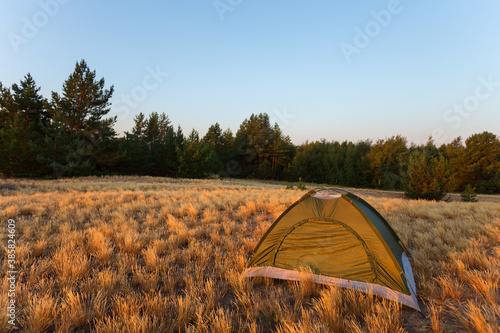 touristic tent among a prairie, early morning touristic camp scene