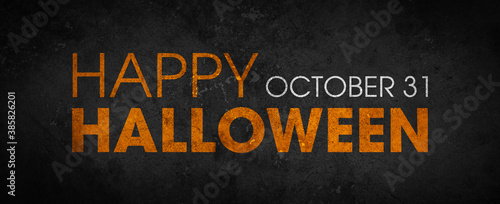 Happy Halloween written in orange on a black grunge cement texture background - October 31st halloween party