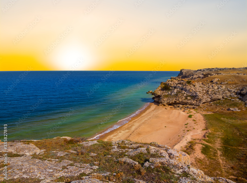 emerald sea bay with stony coast at the sunset