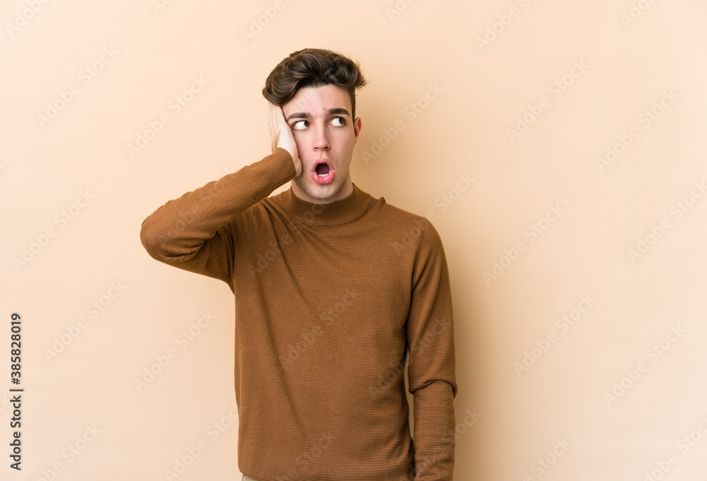 Young caucasian man isolated on beige background being shocked, she has remembered important meeting. Young caucasian man isolated on beige background being shocked, she has remembered important meeting.