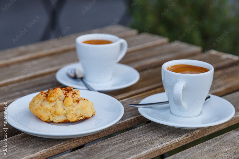 Cup of coffee on table in coffee shop cafe.A cup of coffee and coffee beans with croissant on the table Cup of coffee on table in coffee shop cafe.A cup of coffee and coffee beans with croissant on the table