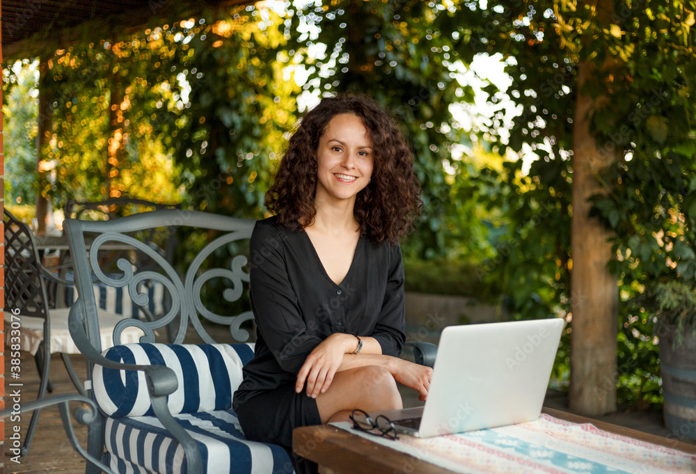 Beautiful Smiling Woman Typing On Notebook Working Online Using Laptop Computer. Female Sitting On Terrace Balcony. Beautiful Smiling Woman Typing On Notebook Working Online Using Laptop Computer. Female Sitting On Terrace Balcony.