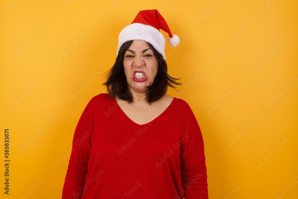 Mad crazy woman isolated over background, clenches teeth angrily, being annoyed with coming noise. Negative feeling concept. Mad crazy woman isolated over background, clenches teeth angrily, being annoyed with coming noise. Negative feeling concept.