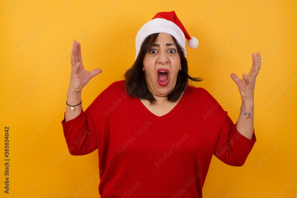 Screaming, hate, rage. Crying emotional angry middle aged woman wearing Santa hat  screaming, Human emotions concept.