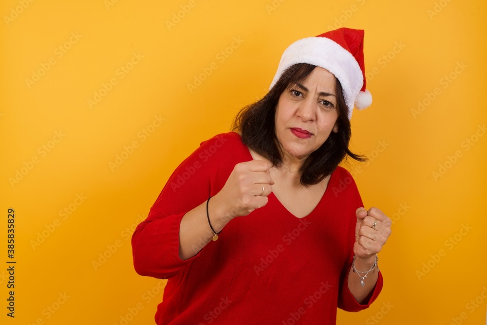 Portrait of attractive young woman with trendy hairstyle and clothes holding hands in front of him in boxing position going to fight. Portrait of attractive young woman with trendy hairstyle and clothes holding hands in front of him in boxing position going to fight.