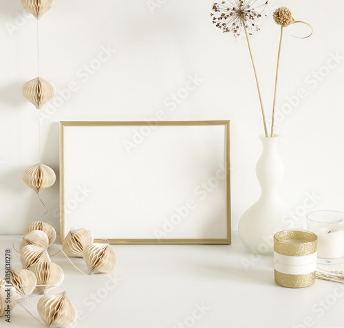 Photo frame mock up  fluffy reeds bouquet in a vase  interiour accessories near the white wall. Copy space template. Minimalist scandinavian interior design .