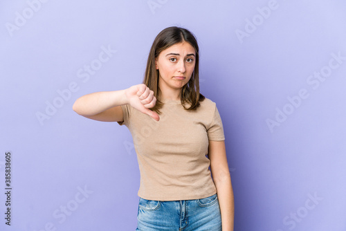 Young caucasian woman showing a dislike gesture, thumbs down. Disagreement concept.