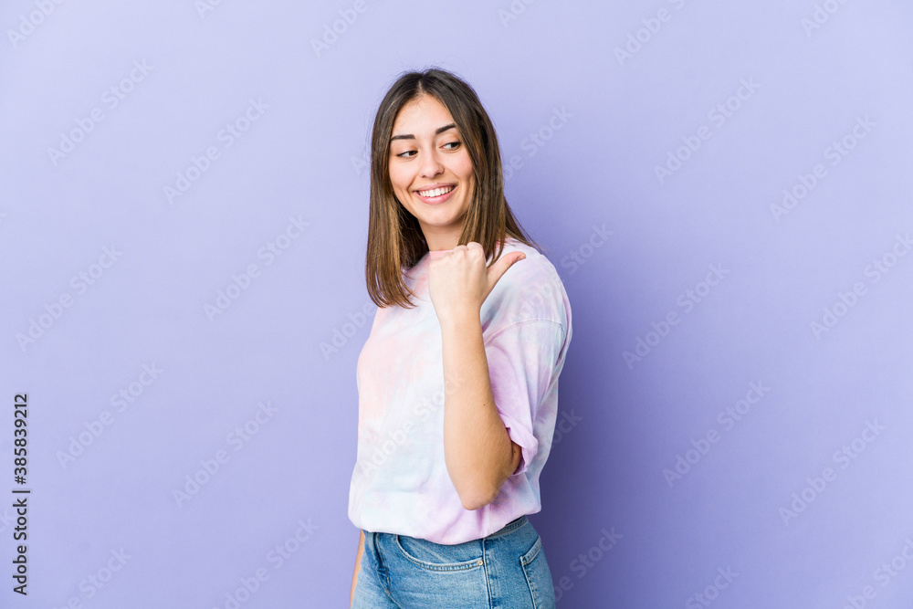 Young caucasian woman points with thumb finger away, laughing and carefree. Young caucasian woman points with thumb finger away, laughing and carefree.