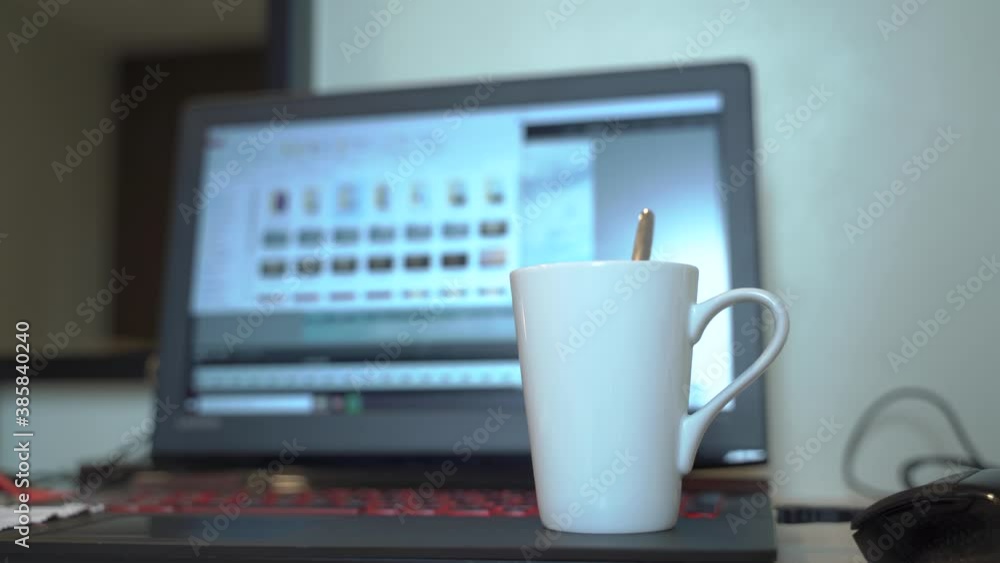 Coffee mugs on the laptop and brewing tea while sitting on the floor in the apartment during work, quarantine and isolation. Work from home. COVID-19 outbreaks of COVID 19. Coffee mugs on the laptop and brewing tea while sitting on the floor in the apartment during work, quarantine and isolation. Work from home. COVID-19 outbreaks of COVID 19.
