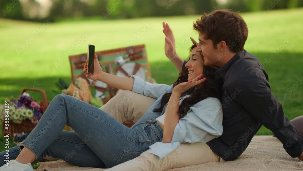 Happy girl and guy having video call in park. Couple sending greetings on phone Happy girl and guy having video call in park. Couple sending greetings on phone