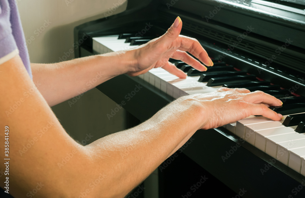 Unrecognizable young caucasian female plays the piano.