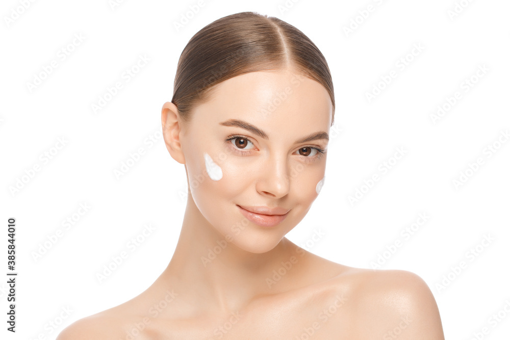 Naklejka premium Beauty portrait of young beautiful woman with face cream on cheeks, isolated on white background