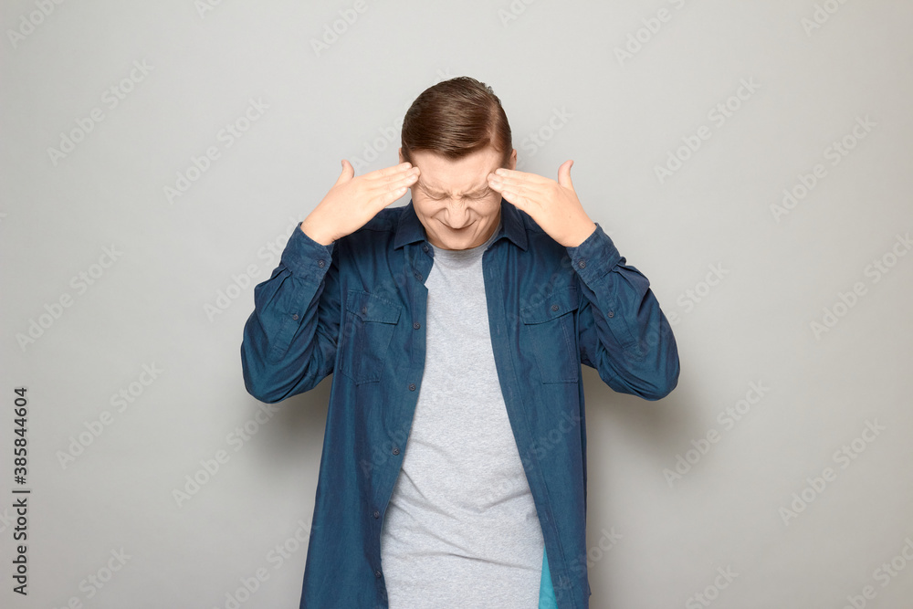 Portrait of unhappy mature man touching temples with hands Portrait of unhappy mature man touching temples with hands