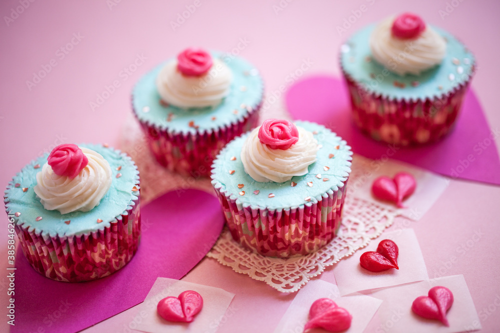 Valentine's Day Cupcakes with Blue Icing with Hearts and Pink Flower Decorations