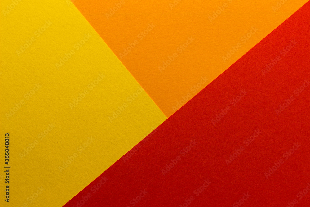 Beautiful multicolored background of yellow, red and orange blank paper sheets with fine texture, close up.