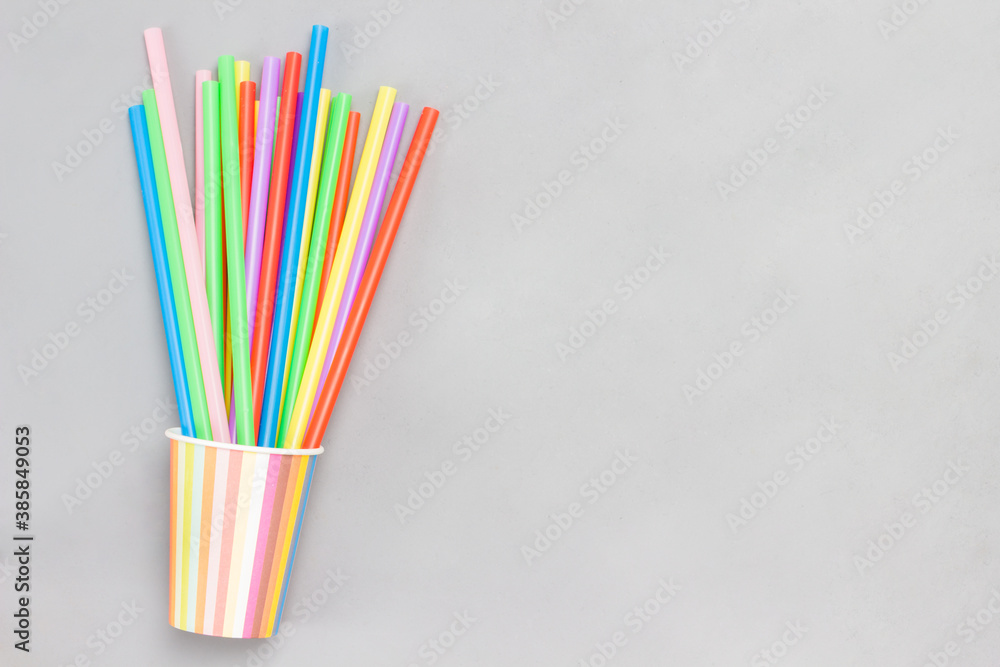 Colorful paper cups and colorful plastic straws for drinks.
