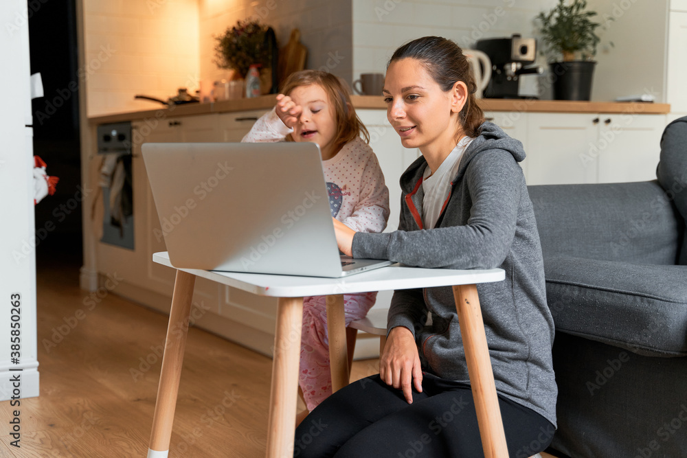 Φωτογραφία Mother and child girl sitting at home ad watching school video on laptop