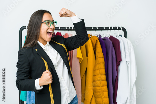 Young asian designer woman isolated on white background raising fist after a victory, winner concept.