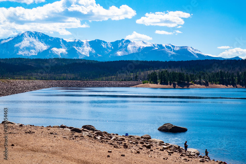distant vacationers on Labor Day weekend enjoying a mountain reservoir with Pikes Peak mountain range in background in September,  Colorado, USA photo
