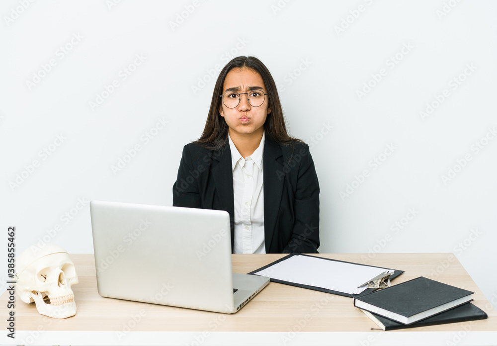 Young traumatologist asian woman isolated on white background blows cheeks, has tired expression. Facial expression concept. Young traumatologist asian woman isolated on white background blows cheeks, has tired expression. Facial expression concept.