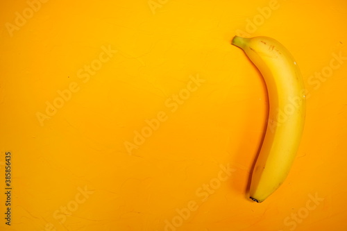 Yellow banana on a yellow textured background. Concept: fruit and healthy food. Space for text