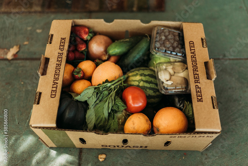 CSA farmers box full of produce on front porch photo