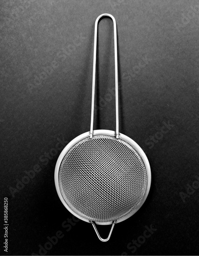 Kitchen utensils, a sieve, on a black background. photo