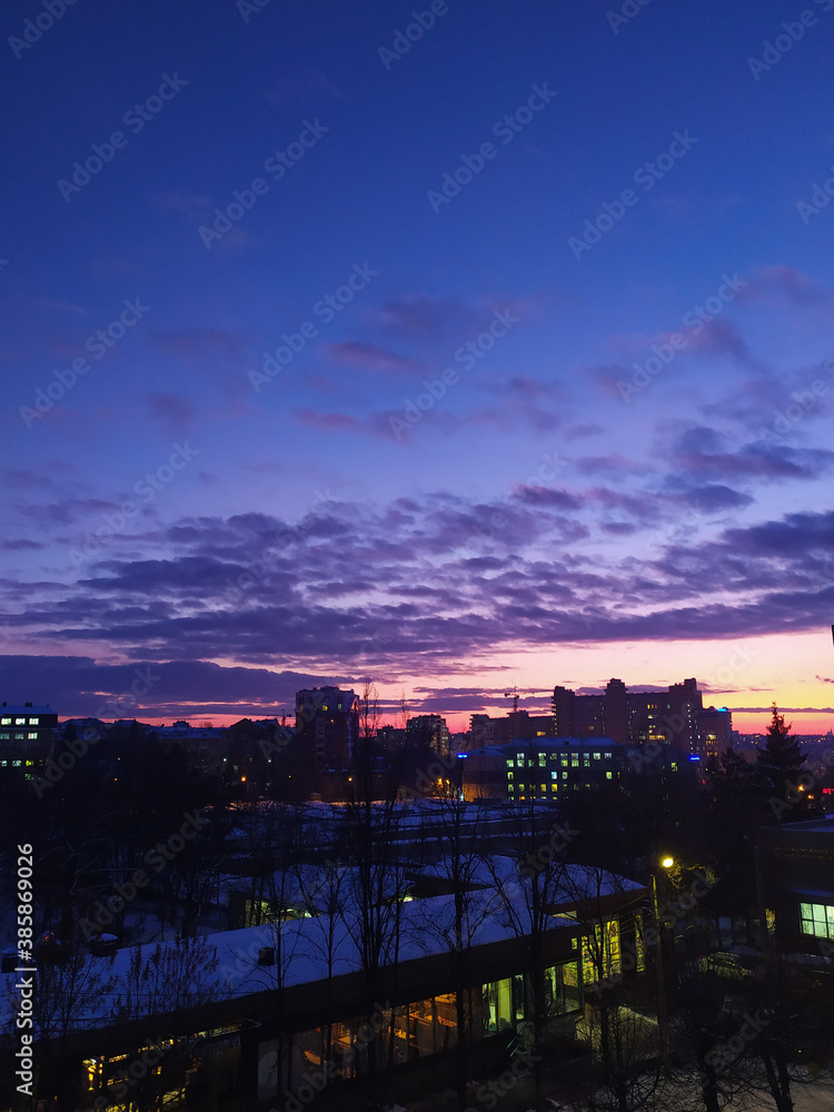 Sunset over the city. The sky after sunset. Purple sky