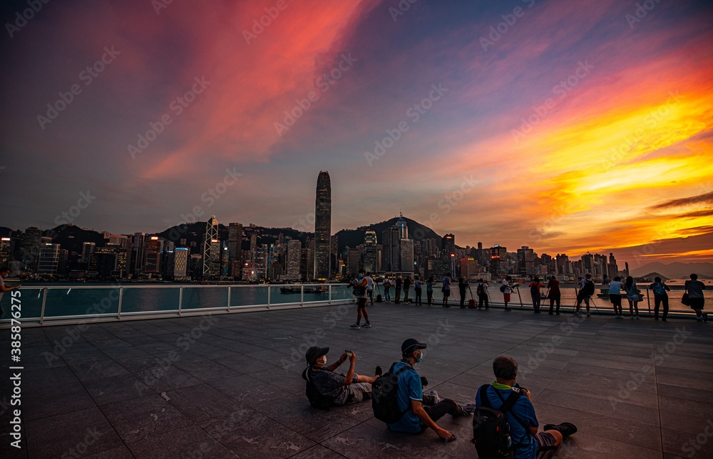 People taking photo in front of beautiful Victoria Harbor in Hong Kong