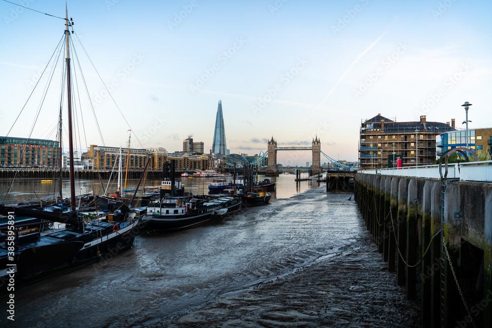 Fototapeta premium City skyline after sunset with the Shard and London Bridge across Thames river with night lights on in London, United Kingdom