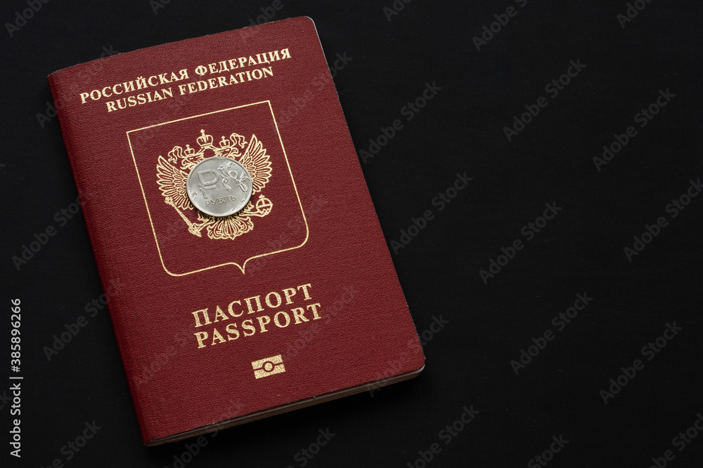 Russian foreign passport with ruble coin on black background. Copy space Russian foreign passport with ruble coin on black background. Copy space
