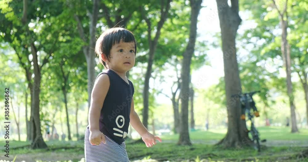 Little cute 2 year boy playingon green grass park recreation activity outdoor sunny day Little cute 2 year boy playingon green grass park recreation activity outdoor sunny day