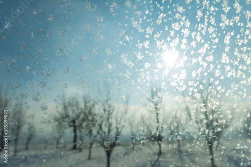Sun rays trough window with frost in the cold winter day