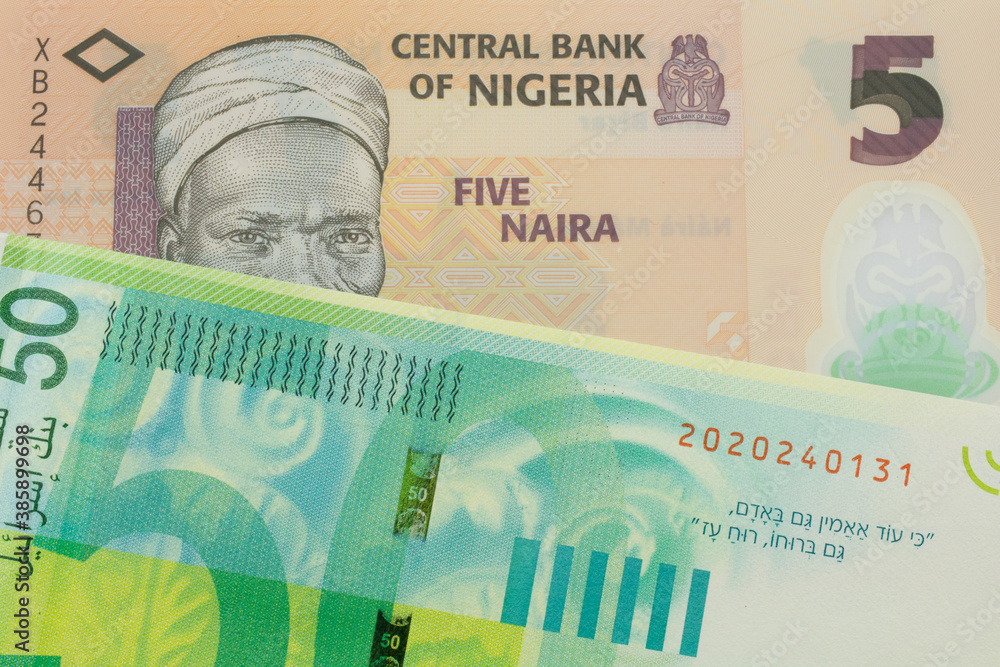 Fototapeta premium A macro image of a orange, plastic five naira note from Nigeria paired up with a green and white fifty shekel bank note from Israel. Shot close up in macro.