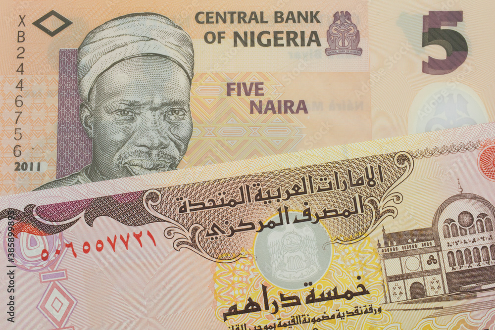 A macro image of a orange, plastic five naira note from Nigeria paired up with a colorful five dinar bank note from the United Arab Emirates.  Shot close up in macro.