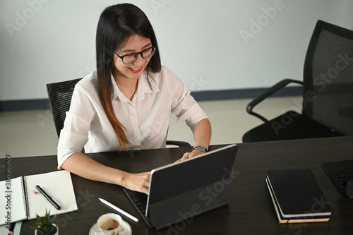 Young beautiful businesswoman working on her project with conputer tablet in office. photo