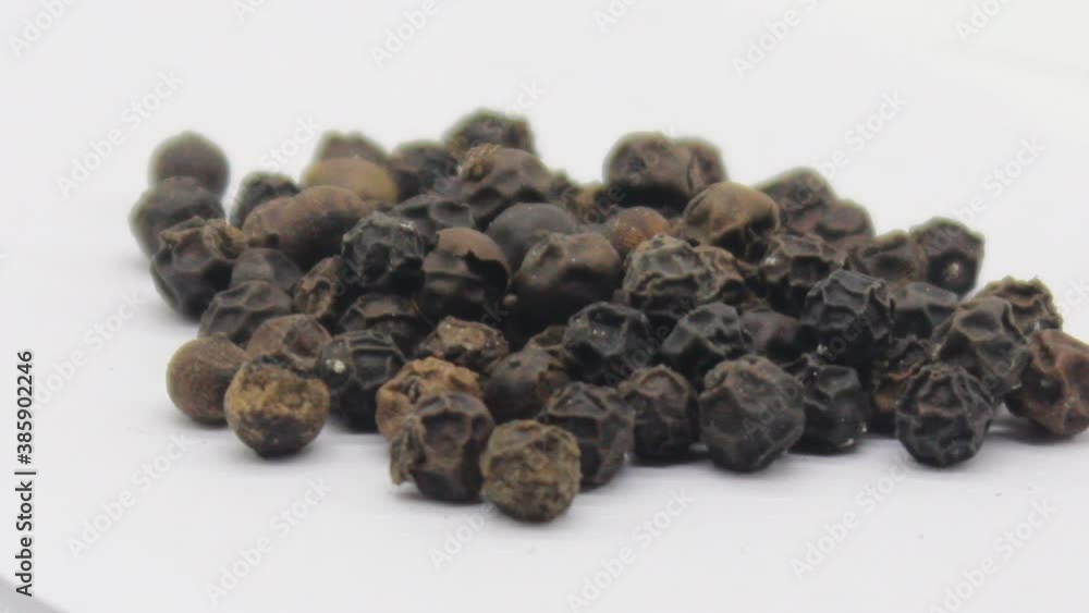 Black pepper on white background with selective focus Black pepper on white background with selective focus