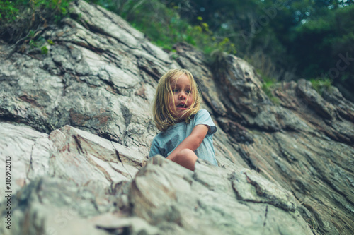 Preschooler climbing rocks on the beach