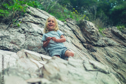 Preschooler climbing rocks on the beach
