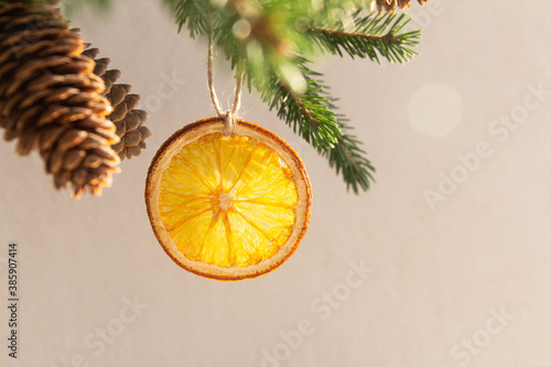 Christmas composition of a Christmas tree with cones, Christmas gifts in craft packaging, slices of dried orange on a white background
