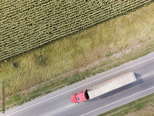 Aerial Top View of the Truck with Cargo Semi Trailer Moving on the Road among the farm fields. Rostov region.