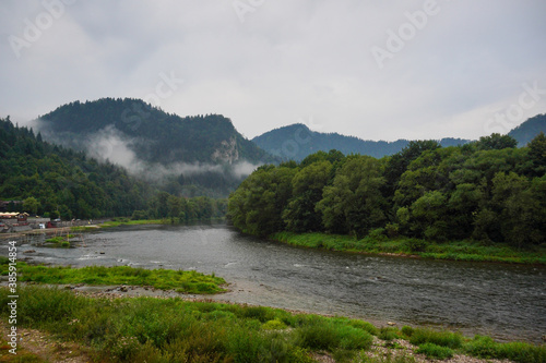 Panorama of the river and mountain view at dawn, fog over the water on a cloudy day. Landscape in Szczawnica, Poland. Beskidy mountains, three crowns trzy korony mountain, Dunajec river