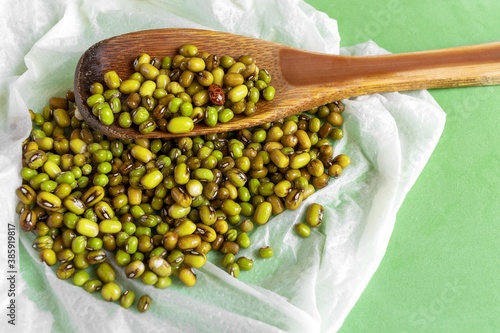 Ungerminated green soybeans isolated on a wooden spoon photo