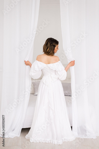 girl in a long white dress in a bright room