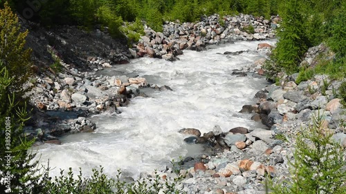 Mountain river Feevispa in Saas-Fee, Valais, Switzerland, splashes over colourful wet stones. In summer the melting glaciers produce a massive amount of cold water. It starts at 2725m below Spielboden photo