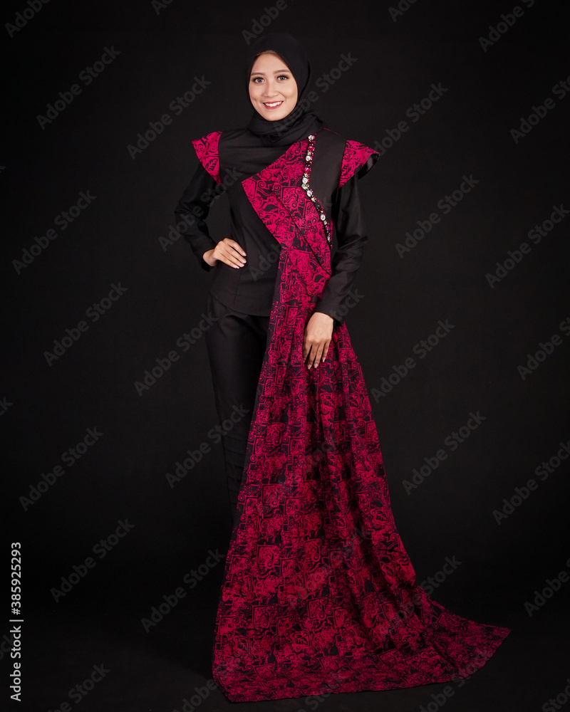 women in hijab are posing like famous models. The woman is wearing a typical Indonesian batik dress. The combination of modern dress designs with red batik that looks elegant. women in hijab are posing like famous models. The woman is wearing a typical Indonesian batik dress. The combination of modern dress designs with red batik that looks elegant.
